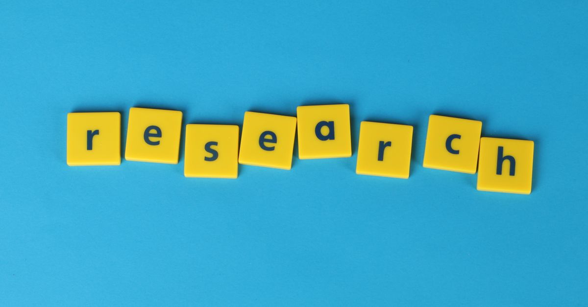 Yellow letter tiles spell the word 'research' on a vibrant blue surface, perfect for educational themes.